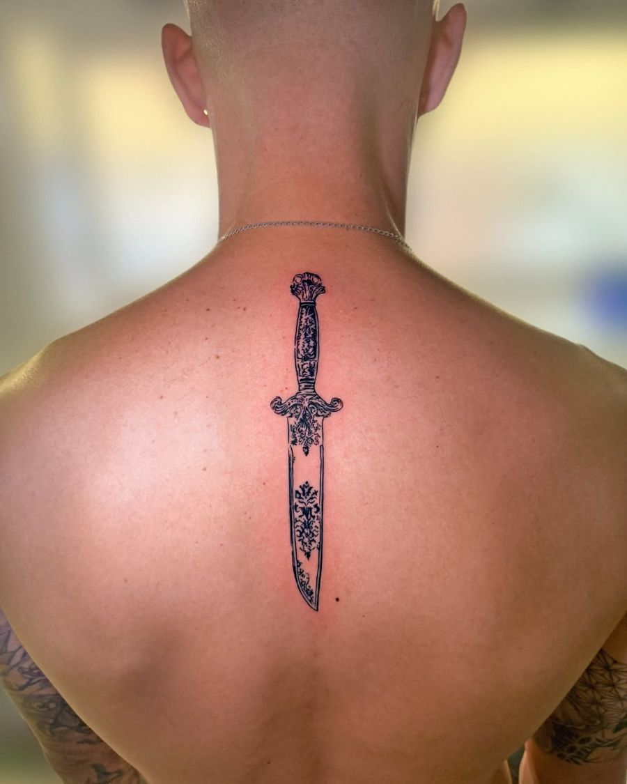 Tatuaje de una daga ornamentada en la espalda