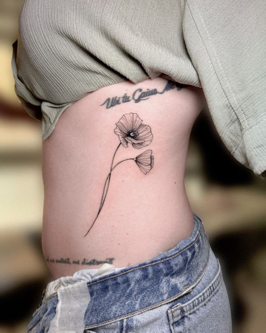 Tatuaje de línea fina de una amapola en las costillas